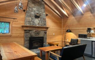 cabin 6 inside view wood stove, large wooden table, futon