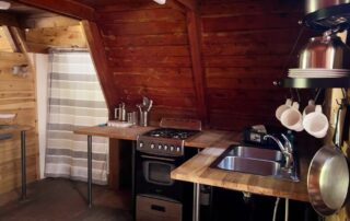 The A Frame is the most secluded of all the cabins and the only cabin with a shower. No electricity, lights are propane-powered. The kitchen has a sink and a propane cook stove. 2025